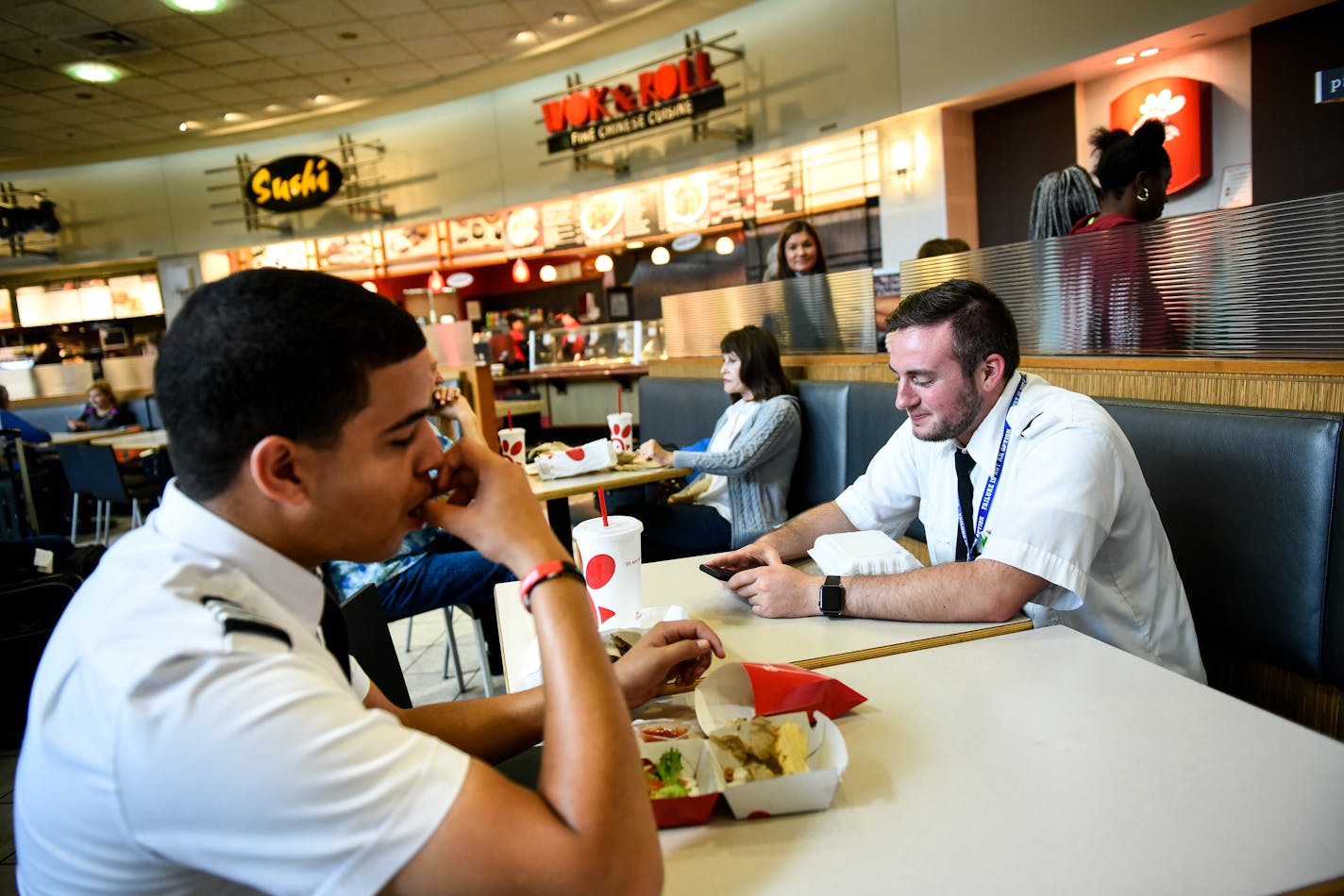 From left, Captain Dylan Brewer, with Air Choice One, and first officer Torrance Hollins, ate lunch in the C Concourse food court before their flight to Fort Dodge, Iowa.