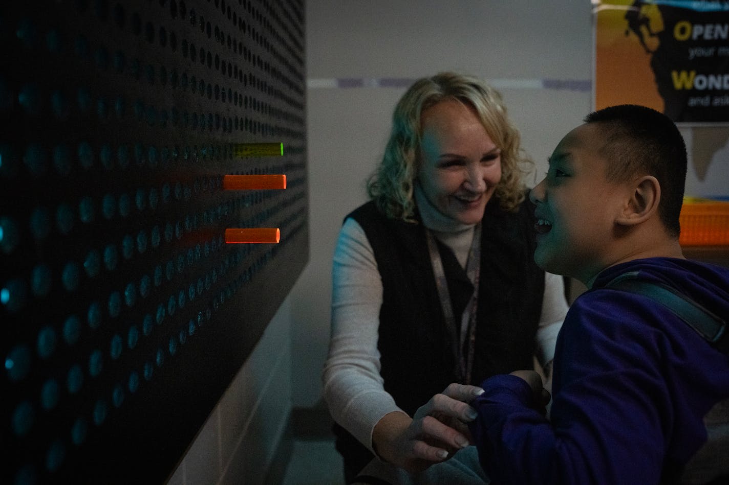 Occupational therapist Cori Smith helps eighth grader ChouChee Yang work on the light board at North View Middle School in Brooklyn Park, Minn., on Thursday, Nov. 30, 2023.