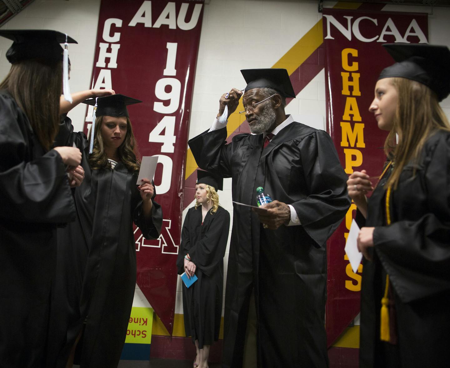 Bobby Bell fixed his tassel with some of his fellow graduating students as they lined up for the procession before Thursday&#x2019;s University of Minnesota commencement at Mariucci Arena. Bell graduated 52 years after leaving school for pro football.