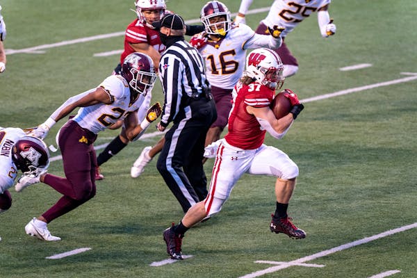 Wisconsin fullback Mason Stokke (34) runs for a touchdown ahead of Minnesota defenders Jordan Howden (23) and Coney Durr (16) during the first half of