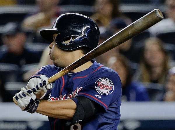 Minnesota Twins' Kurt Suzuki follows through on a base hit to right field to drive in a run against the New York Yankees during the eighth inning on F