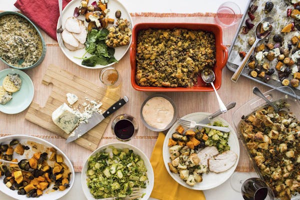This October 2017 photo taken in New York, shows a Thanksgiving spread with hot spinach and mushroom dip, turkey, cornbread stuffing and sauteed bruss