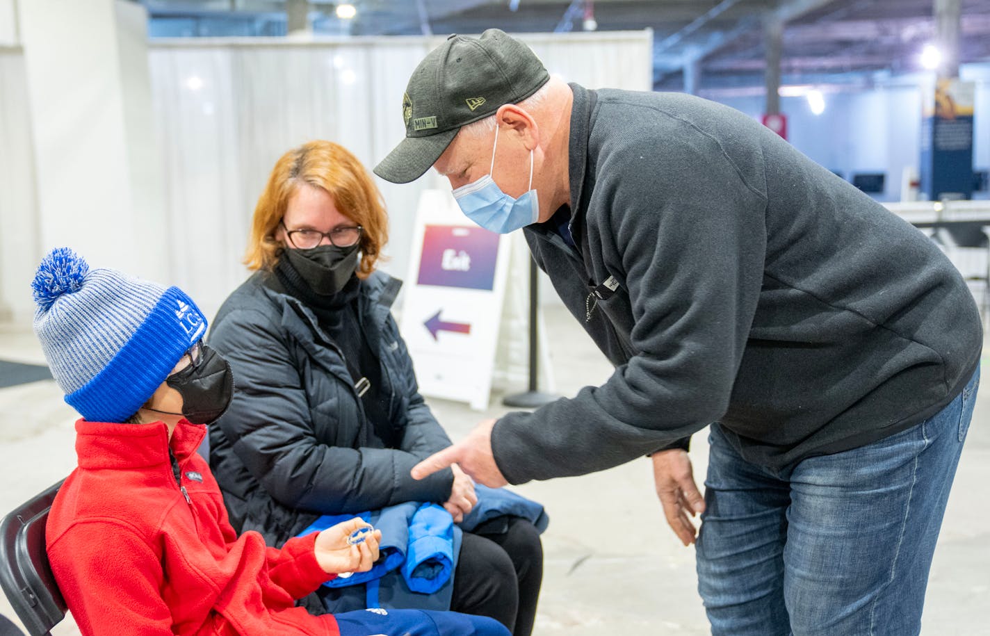 Minnesota Governor Tim Walz thanks Max Boulger, 10, for receiving his COVID-19 booster shot while his mother, Marsha Huha, looks on Friday, Dec. 30, 2022 at the Minnesota Department of Health Community Vaccination Program Site at the Mall of America in Bloomington, Minn. The site closes its doors permanently at 8PM the same night. ]