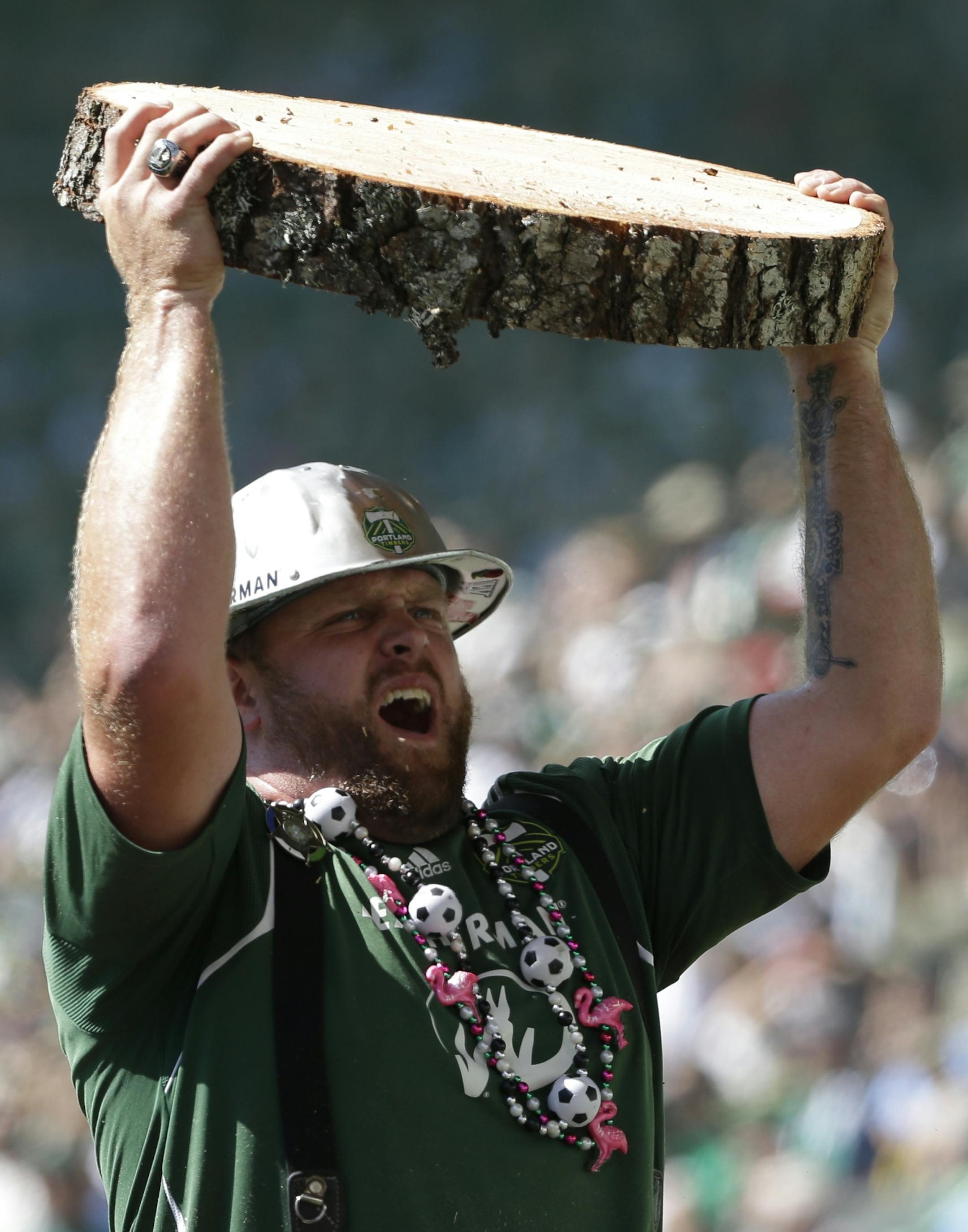 Joey Webber, also known as ìTimber Joey," holds a section of the log he cuts with a chain saw after every Portland Timbers goal, during an MLS soccer match against the Seattle Sounders, Sunday, Aug. 28, 2016, in Portland, Ore. (AP Photo/Ted S. Warren) ORG XMIT: OTK