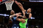 Karl-Anthony Towns of the Wolves battled for position against Grizzlies Brandon Clarke (15) and Desmond Bane on Monday night.