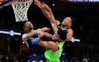 Karl-Anthony Towns of the Wolves battled for position against Grizzlies Brandon Clarke (15) and Desmond Bane on Monday night.