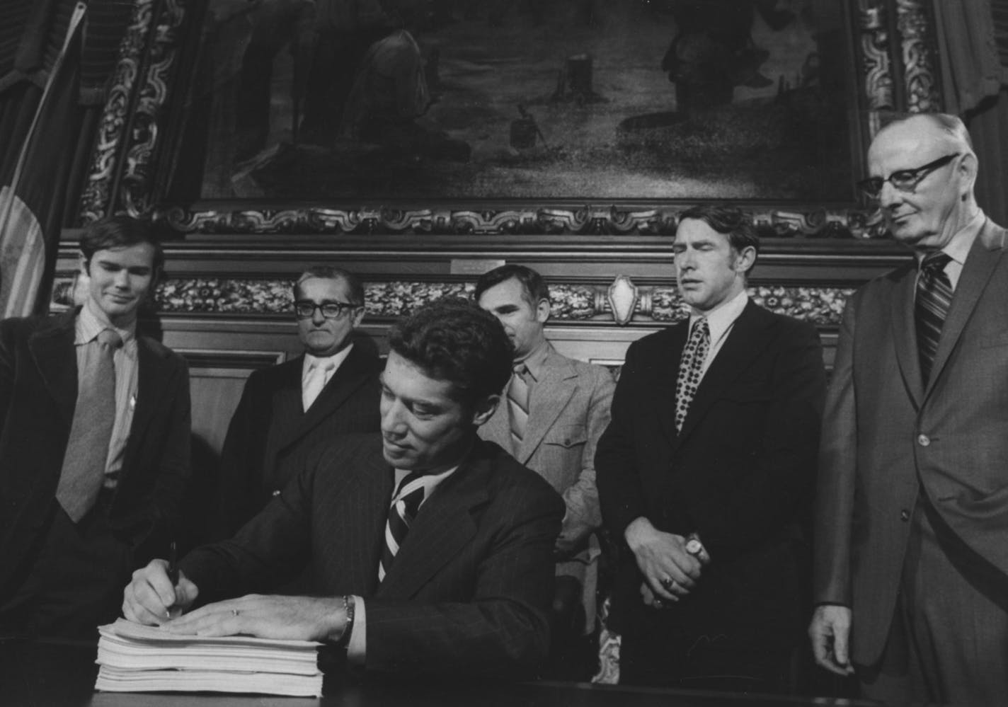 Gov. Wendell Anderson signed the omnibus tax bill in 1971. It was to raise about $580 million in new revenues. Watching, from left, were John Haynes, Anderson's tax aide; State Sen. Harold Kalina; Rep. Irv Anderson, Rep. Martin Sabo, and Rep L.J. Lee. Minneapolis Tribune (now Star Tribune) staff photo by Duane Braley, October 30, 1971. ORG XMIT: MIN2016071812564346