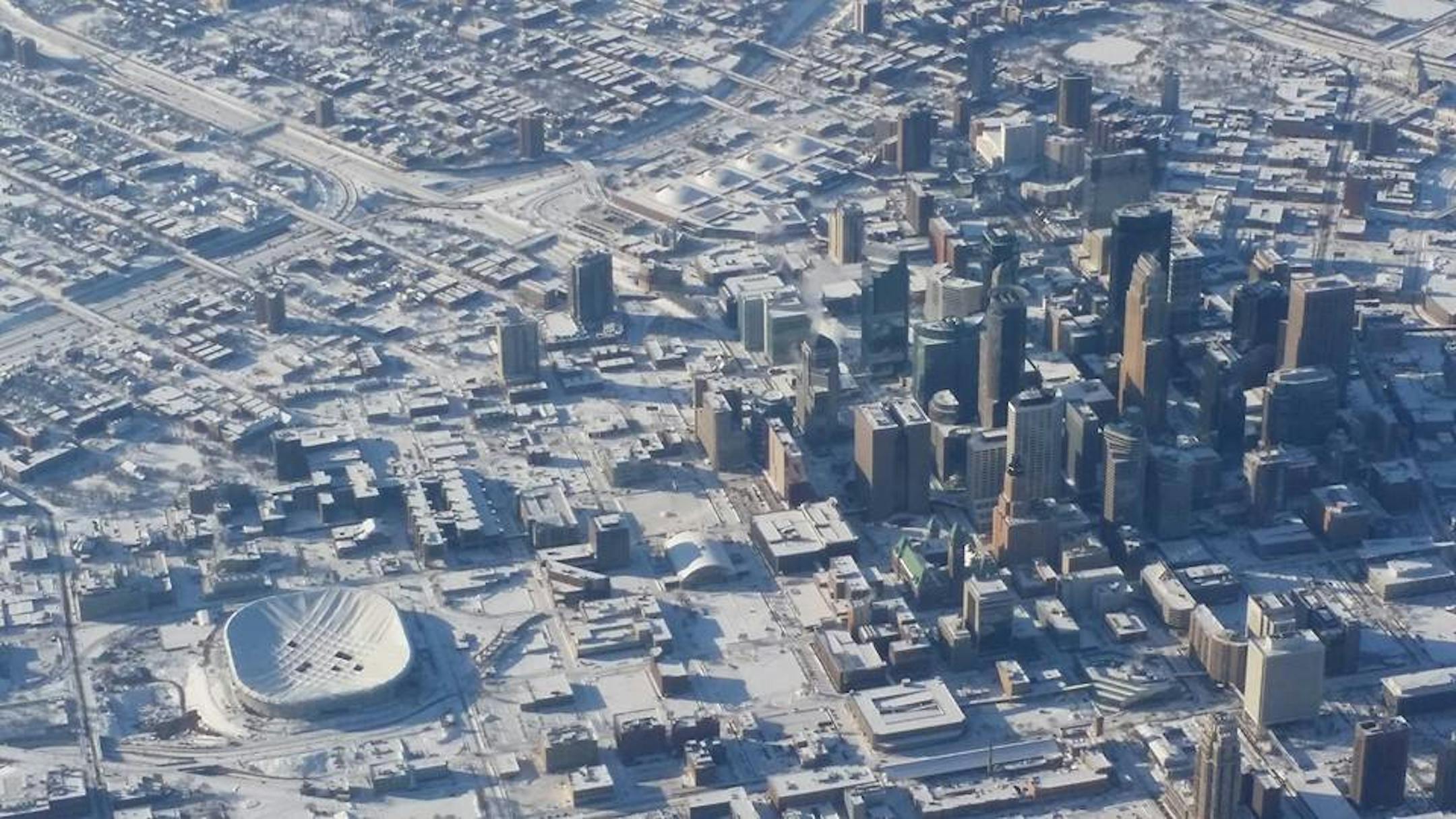 As the sun rose over a snowy downtown Minneapolis on Saturday morning, January 18, 2014, workers were already dismantling the deflated roof of the Metrodome.