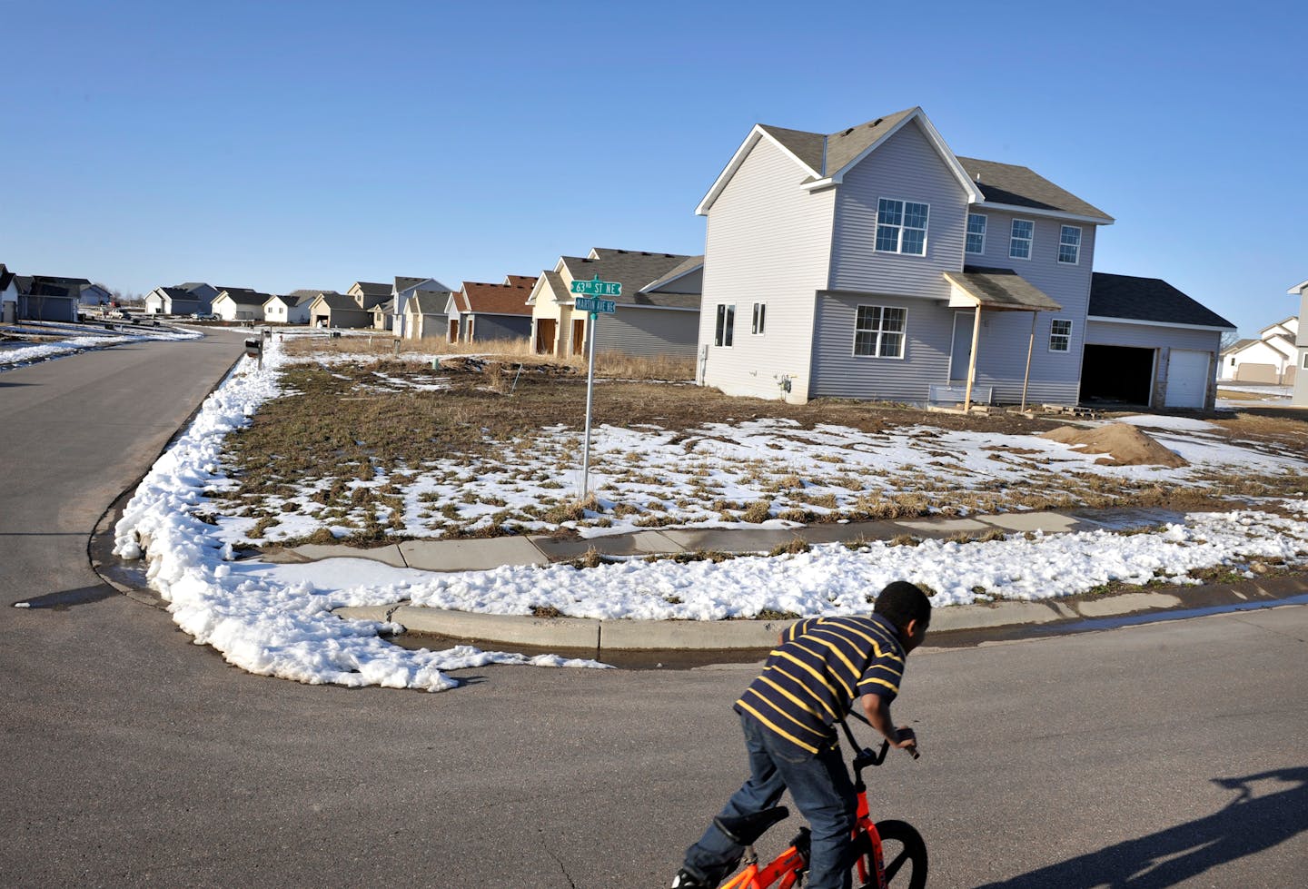 A child scoots along 63rd Ave NE in Otsego Preserve, an area with a high number of foreclosed and unsold homes.