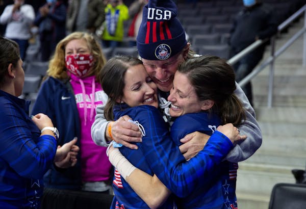 Team Peterson's Tabitha Peterson, left, and Tara Peterson, right, hug their father, Sheldon Peterson, following their victory over Team Christensen du