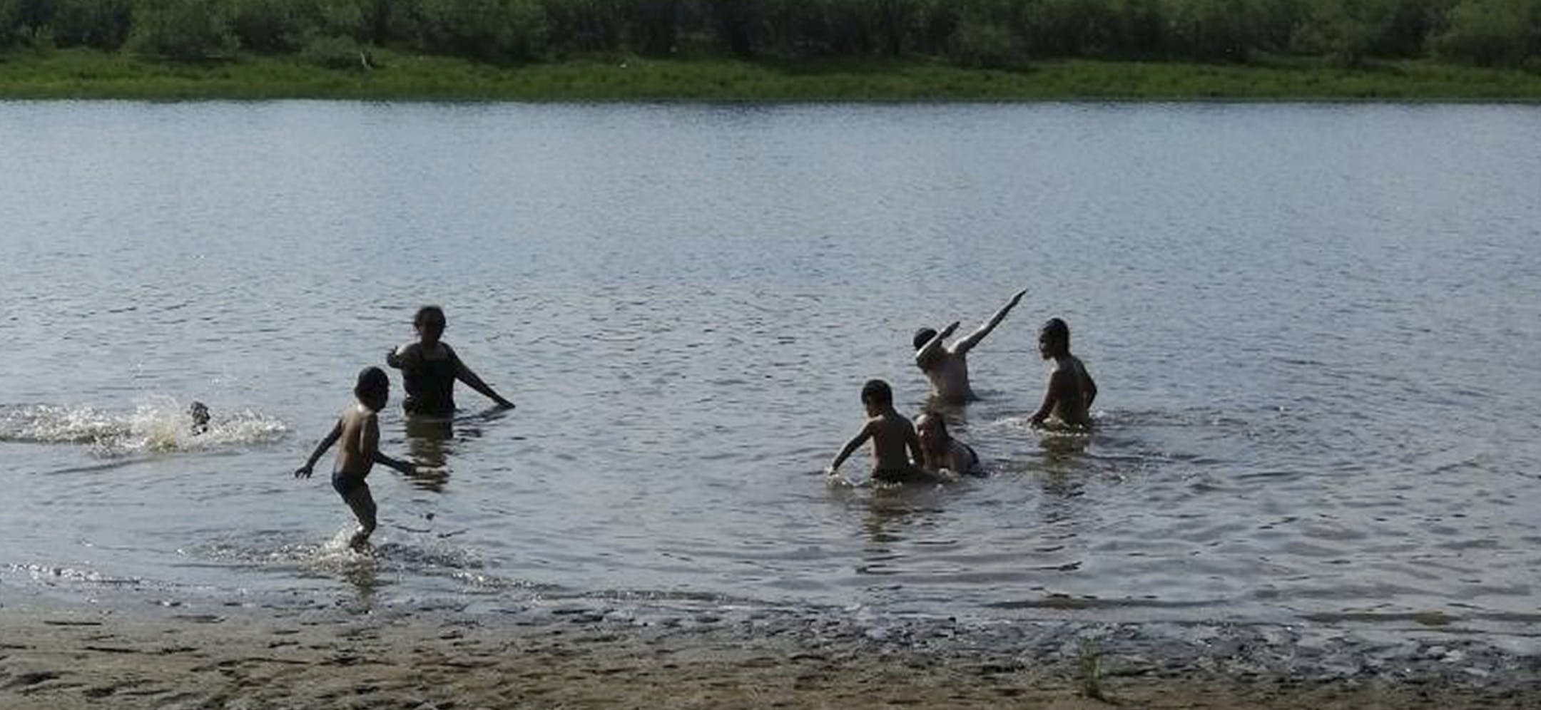 In this handout photo provided by Olga Burtseva, children play in the Krugloe lake outside Verkhoyansk, the Sakha Republic, about 4660 kilometers (2900 miles) northeast of Moscow, Russia, Sunday, June 21, 2020. A Siberian town that endures the world's widest temperature range has recorded a new high amid a hear wave that is contributing to severe forest fires. Russia's meteorological service said the thermometer hit 38 Celsius (100.4 F) on Saturday in Verkhoyansk, in the Sakha Republic about 466