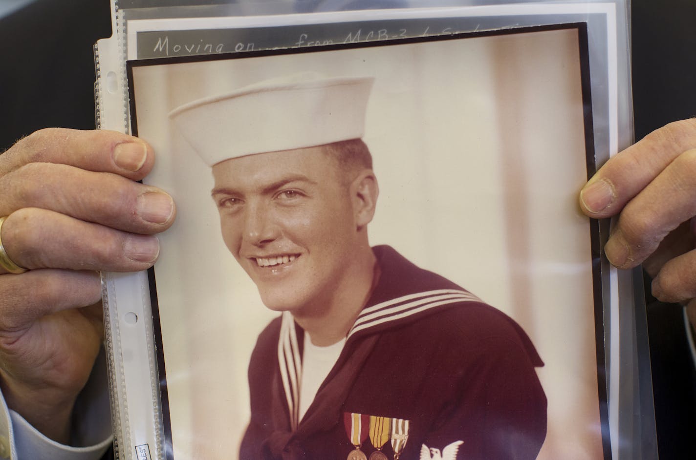 At Monday's ceremony, Fred Jenness held a photo of himself from 1969 when he was a Seabee combat engineer. He was wounded in the leg by the enemy but returned fire to end the attack.