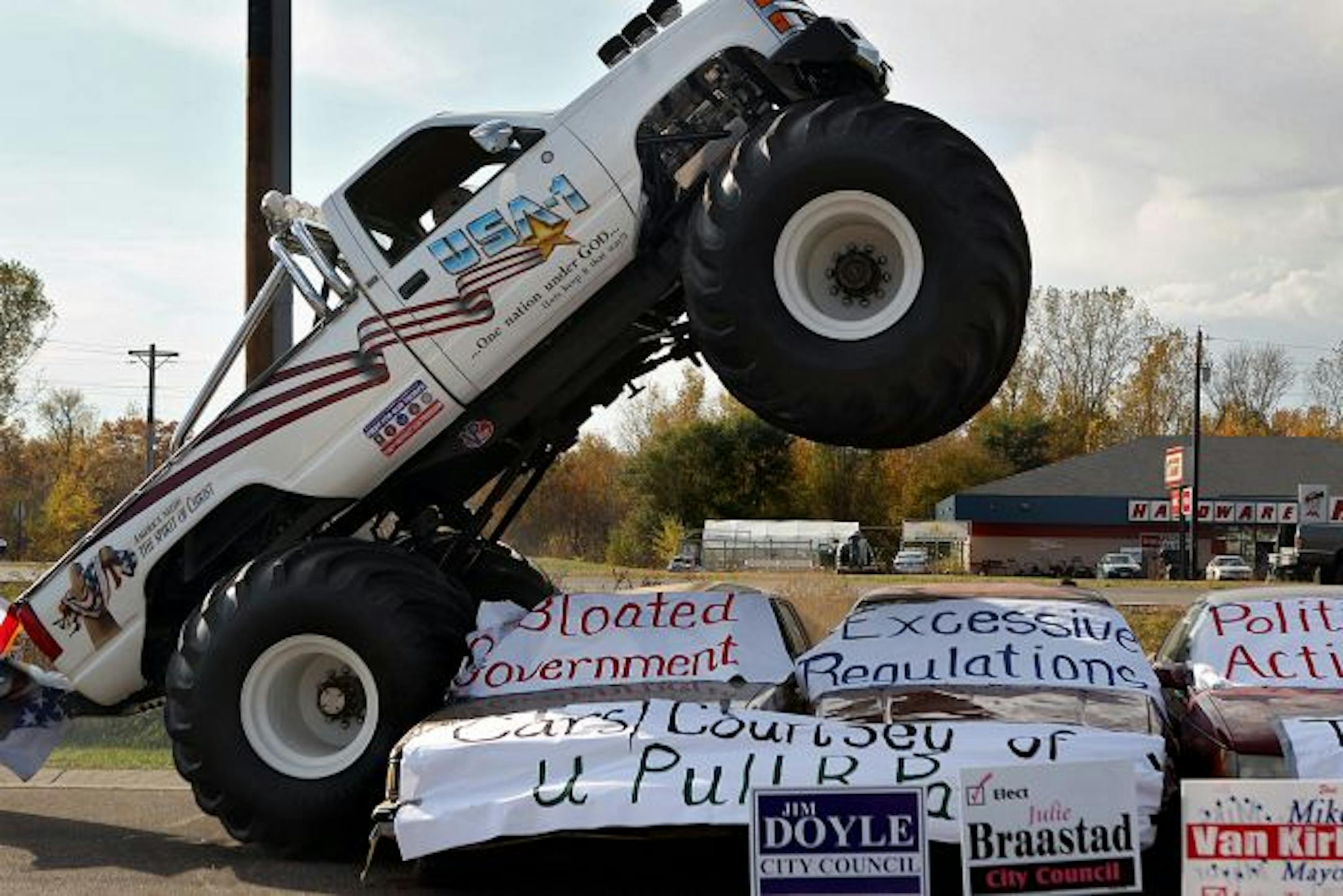 Many members of the crowd captured the moment as Tea Party supporter Everett Jasmer drove a monster truck over cars adorned with political messages at a "Tax Crush Rally" in Ham Lake on Saturday.