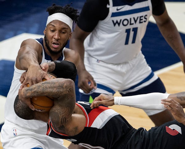 Josh Okogie (20) of the Minnesota Timberwolves and Damian Lillard (0) of the Portland Trailblazers fought for the ball in the first quarter.