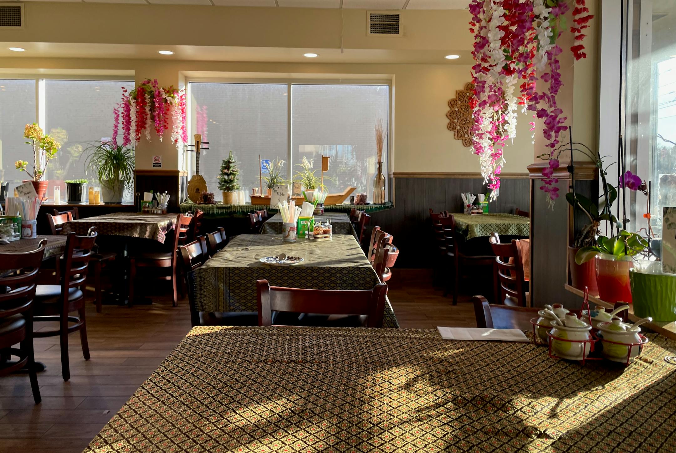 The inside of Basil Cafe with tapestry tablecloths and floral installations.