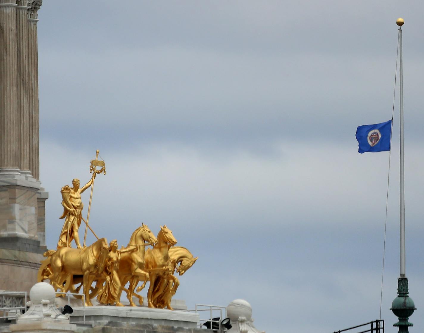 The Minnesota State flag flies at half staff near The Quadriga at the State Capitol Tuesday, May 19, 2020, in St. Paul, MN. Governor Tim Walz today announced that every month on the 19th, flags will fly at half staff to honor those who have died from COVID-19.]