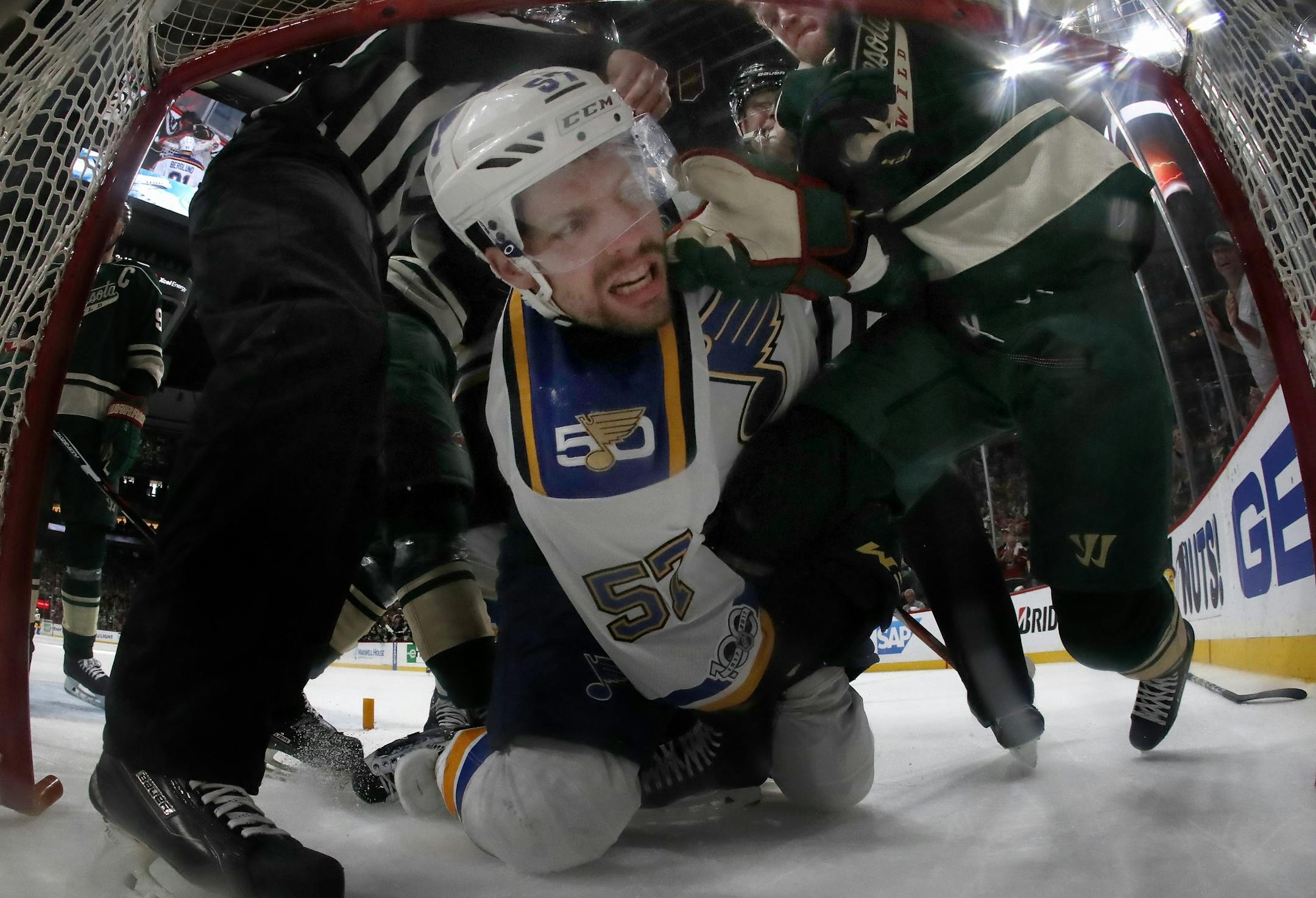 David Perron (57) tangled up with Ryan Suter (20) in the Wild net during the third period.