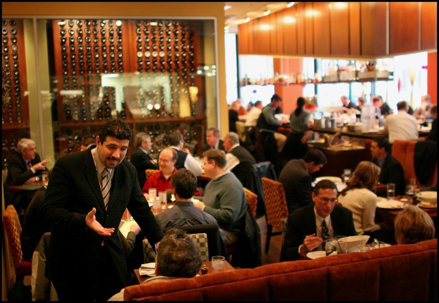 The year in review project looks at several highlights from the year 2004 and will break down the best of the year. Anoush Ansari seats a customer in an already full Mission American dining room.