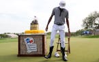 Akshay Bhatia tries on a pair of cowboy boots after winning the Texas Open on Sunday in San Antonio.