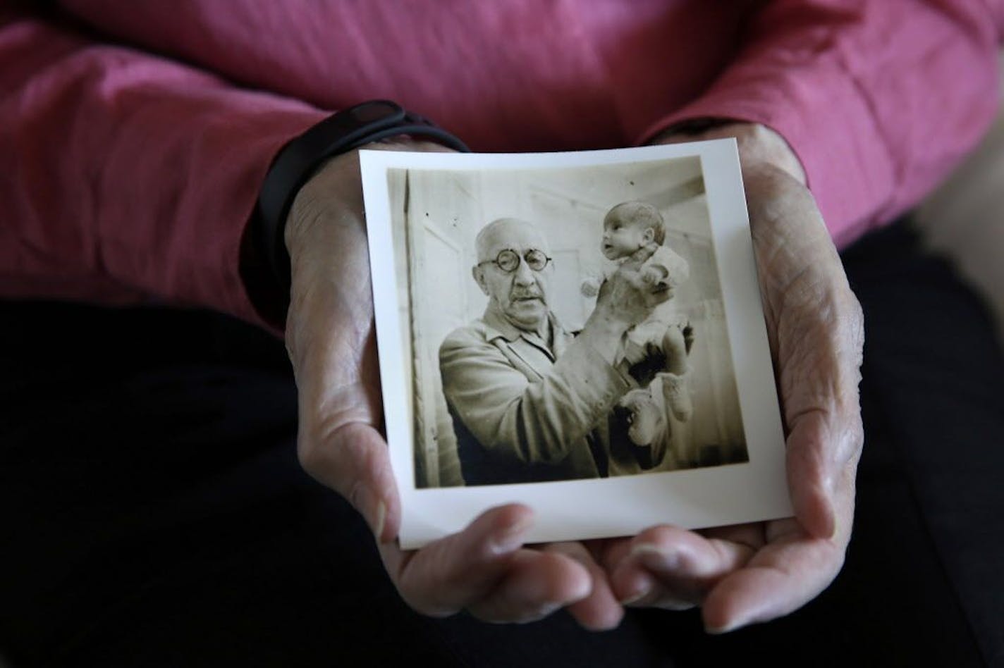 In this photo taken Thursday, July 23, 2015, Beth Allen holds a photograph taken by her father that shows her being held by Dr. Martin Couney at his Coney Island incubator sideshow, where she was on display with others after she was born premature in 1941, at her home in Hackensack, N.J. A century before reality TV, premature infants were put on display in primitive incubators. People paid 25 cents to see them at world's fairs, on the Atlantic City boardwalk, the sideshows at Coney Island and el