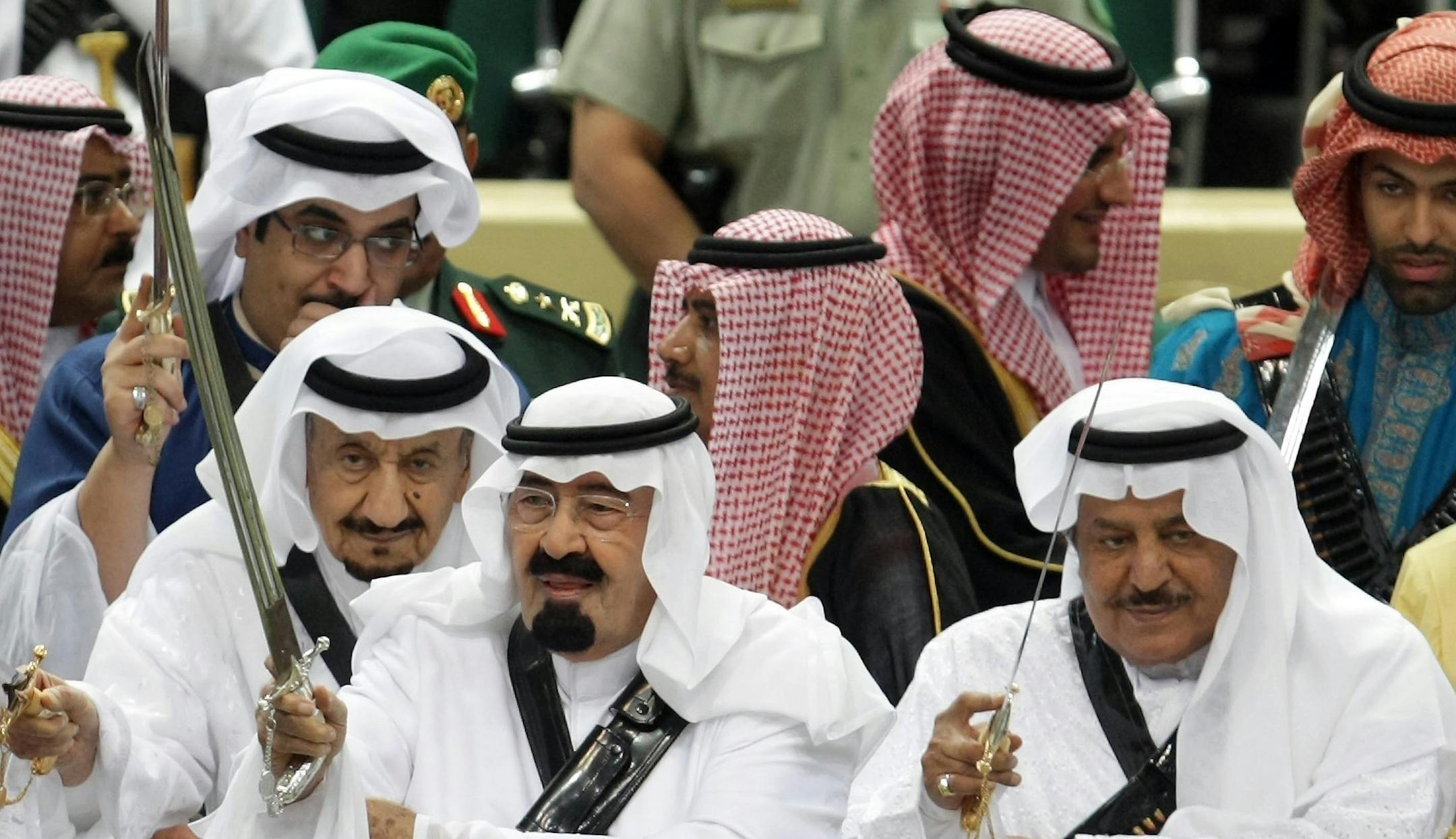 FILE - In this Tuesday, March 23, 2010 file photo, King Abdullah, center, of Saudi Arabia and his half brother Saudi Interior Minister Prince Nayef bin Abdul Aziz al-Saud, right, hold their swords as they take part in the traditional Arda dance, or War dance, during the Janadriyah Festival of Heritage and Culture on the outskirts of Riyadh, Saudi Arabia. King Abdullah has ratified a new counter-terrorism law which went into effect Sunday, Feb. 2, 2014. Rights activists said that the law criminal