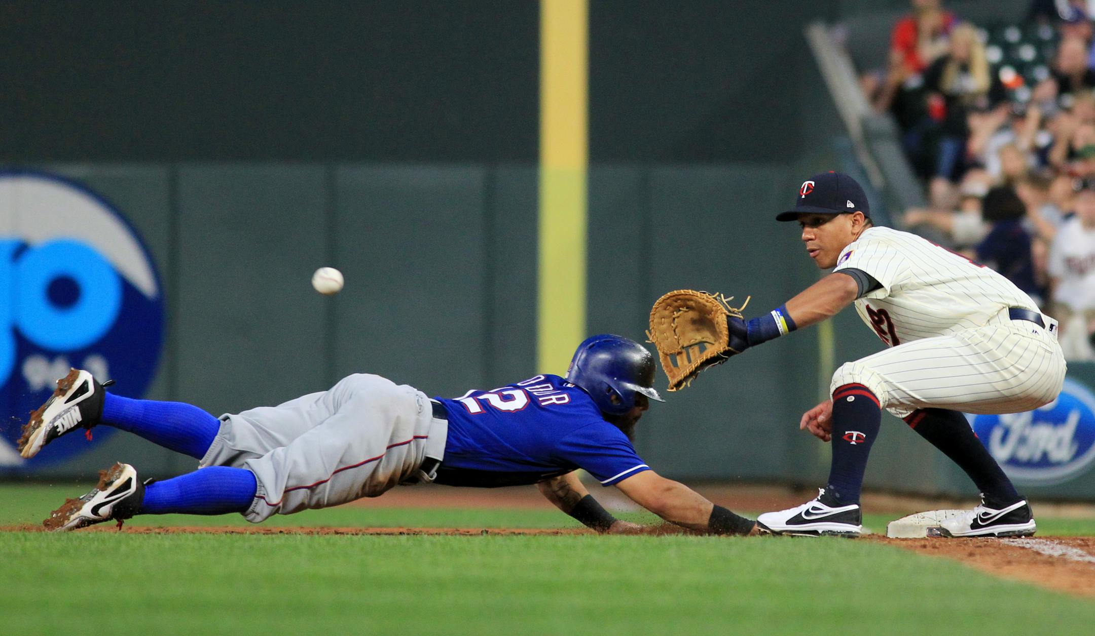 Texas Rangers' Rougned Odor (12) dives back to first base as Minnesota Twins first baseman Ehire Adrianza (16) waits for the throw during the sixth inning of a baseball game Saturday, Aug. 5, 2017 in Minneapolis. The Rangers won 4-1. (AP Photo/Andy Clayton-King)