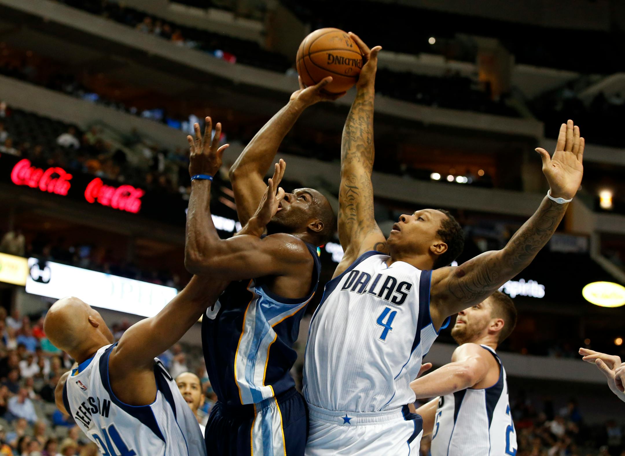 Memphis Grizzlies' Quincy Pondexter, center, fights for a shot attempt against Dallas Mavericks' Richard Jefferson, left, Greg Smith (4) and Gal Mekel, right, in the second half of a preseason NBA basketball game, Monday, Oct. 20, 2014, in Dallas. The Mavericks won 108-103. (AP Photo/Tony Gutierrez)