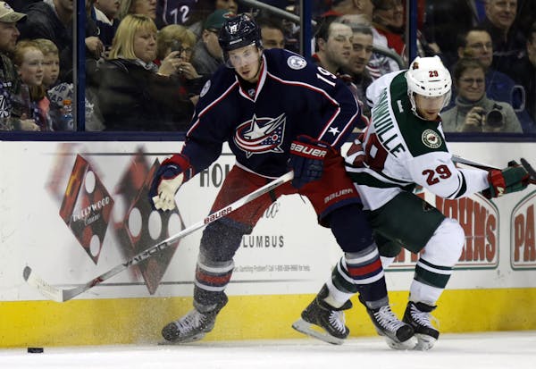 Columbus Blue Jackets' Ryan Johansen, left, works for the puck against Minnesota Wild's Jason Pominville during an NHL hockey game in Columbus, Ohio, 