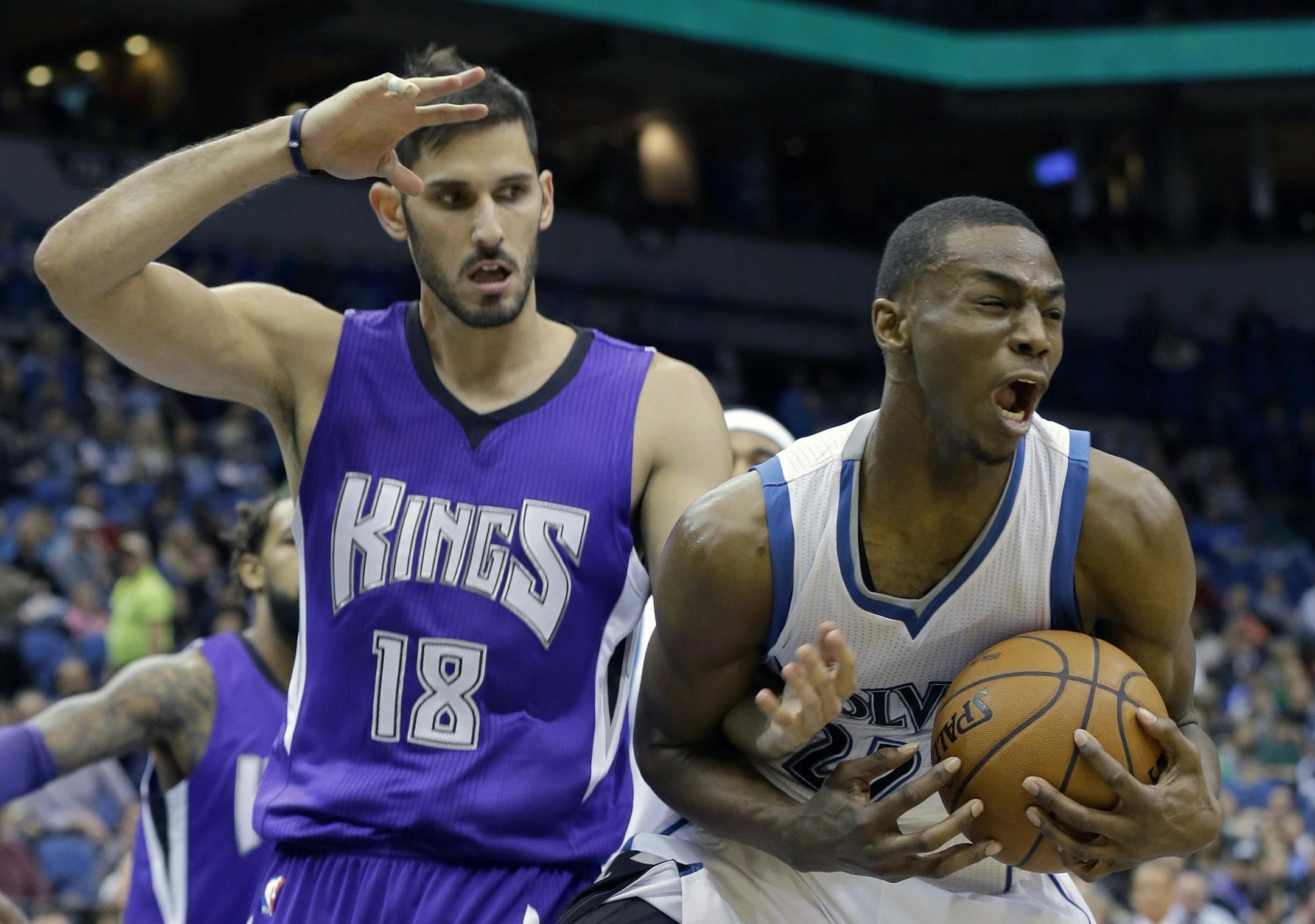Minnesota Timberwolves forward Andrew Wiggins, right, wrestles a rebound away from Sacramento Kings forward Omri Casspi (18), of Israel, during the first quarter of an NBA basketball game in Minneapolis, Saturday, Nov. 22, 2014.