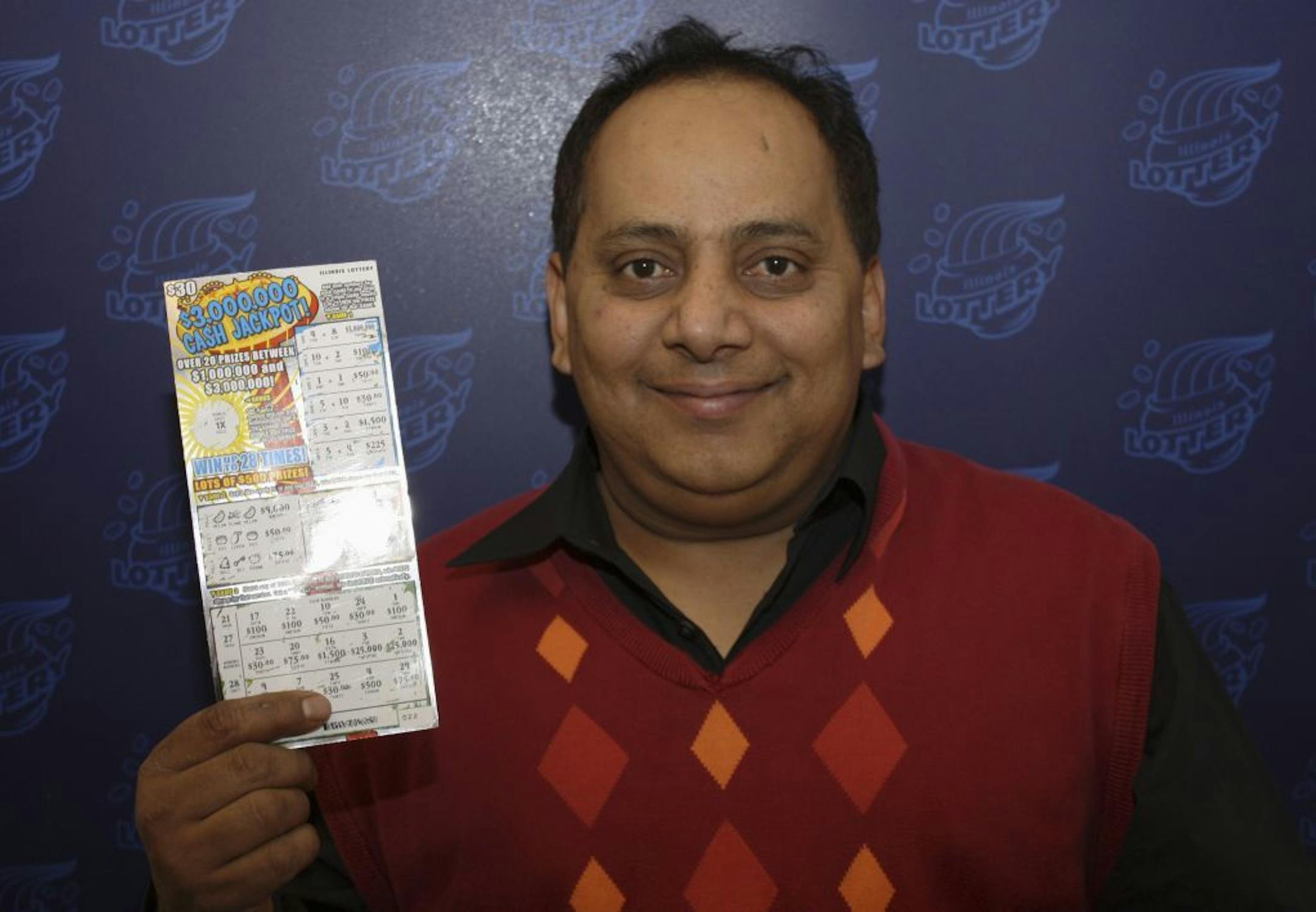 This undated photo provided by the Illinois Lottery shows Urooj Khan, 46, of Chicago's West Rogers Park neighborhood, posing with a winning lottery ticket. The Cook County medical examiner said Monday, Jan. 7, 2013, that Khan was fatally poisoned with cyanide July 20, 2012, a day after he collected nearly $425,000 in lottery winnings.