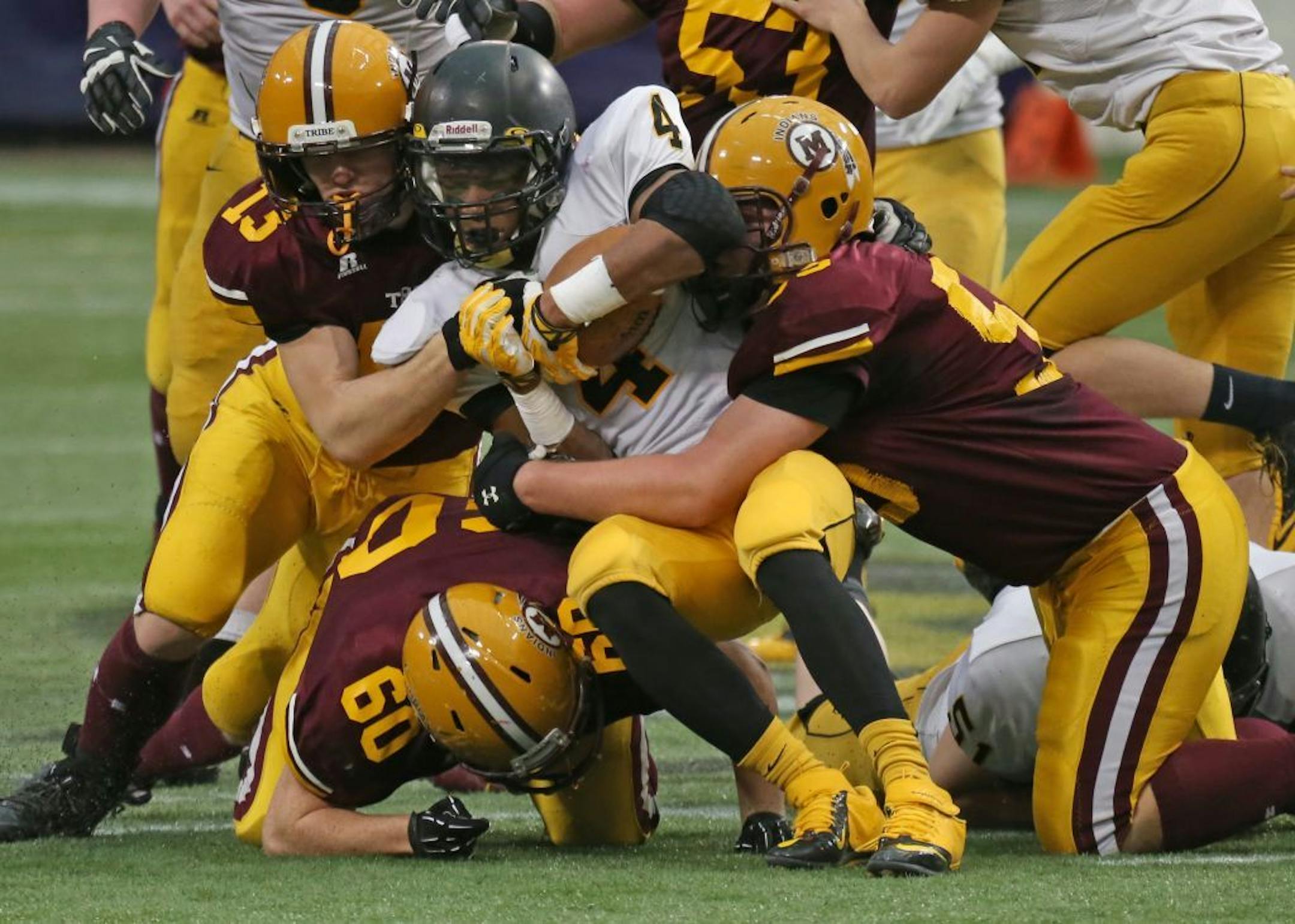 Michael Anyasike ( No. 4), a running back with Dawson-Boyd, was tackled during the state High School League Prep Bowl Class 1A Championship game in the Metrodome on Nov. 30, 2013. s.