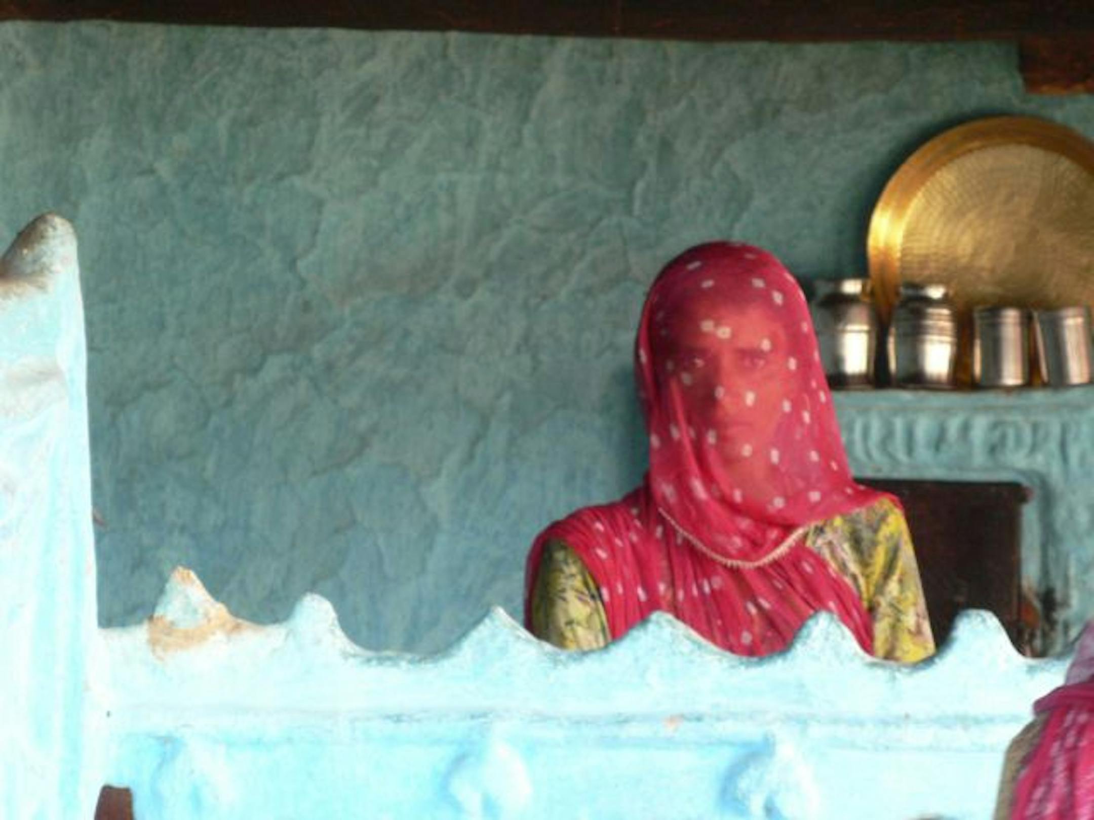 A woman looks up from her kitchen work in a village outside of Jodhpur. Traveling in Rajasthan with a tour company allowed for immersion with locals and the ability to find calm amid India's chaos.