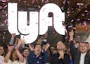 Lyft co-founders John Zimmer, front second from left, and Logan Green, front second from right, cheer as they as they ring a ceremonial opening bell i