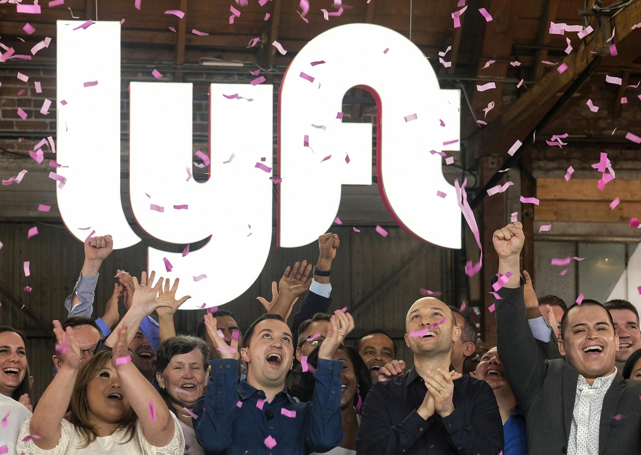 Lyft co-founders John Zimmer, front second from left, and Logan Green, front second from right, cheer as they as they ring a ceremonial opening bell in Los Angeles, Friday, March 29, 2019. On Friday the San Francisco company's stock will begin trading on the Nasdaq exchange under the ticker symbol "LYFT." (AP Photo/Ringo H.W. Chiu) ORG XMIT: CARC101