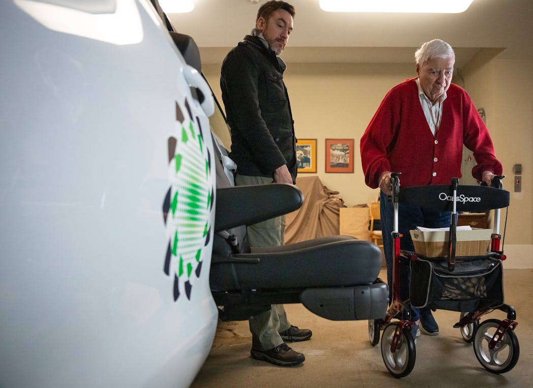 With assistance from Edwards Safe Passage co-founder Michael Lynds, left, Burt Cohen demonstrated how a remote controlled seat allows him to get in and out of an Edwards Safe Passage van in Edina on Jan. 18.