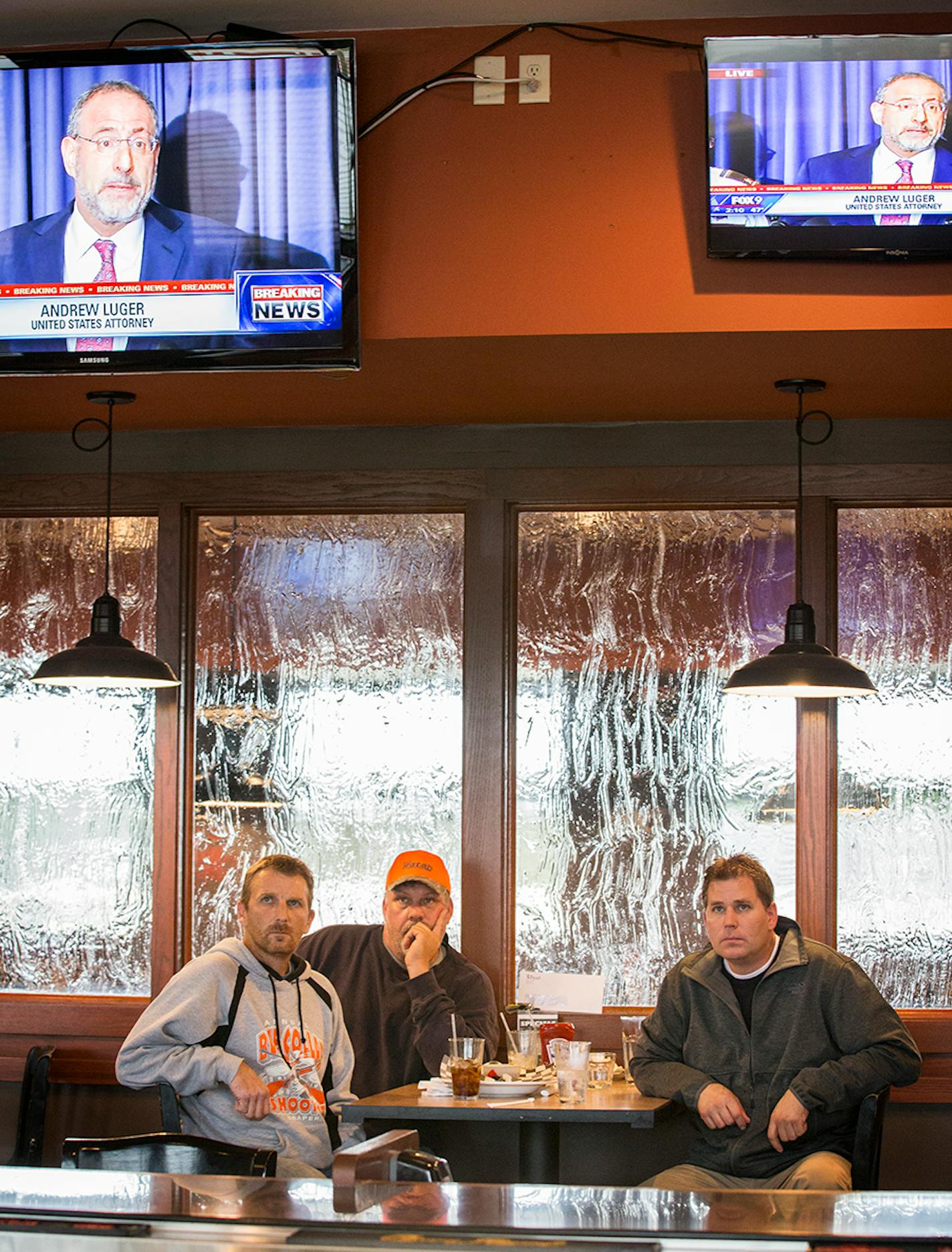 Tim Haeg, from left, Kevin Cox and Mike Wassman watch a press conference revealing a new "person of interest" in the Jacob Wetterling case at American Burger Bar in St. Joseph on Thursday, October 29, 2015. Haeg and Cox grew up in St. Joseph and remember the case well.