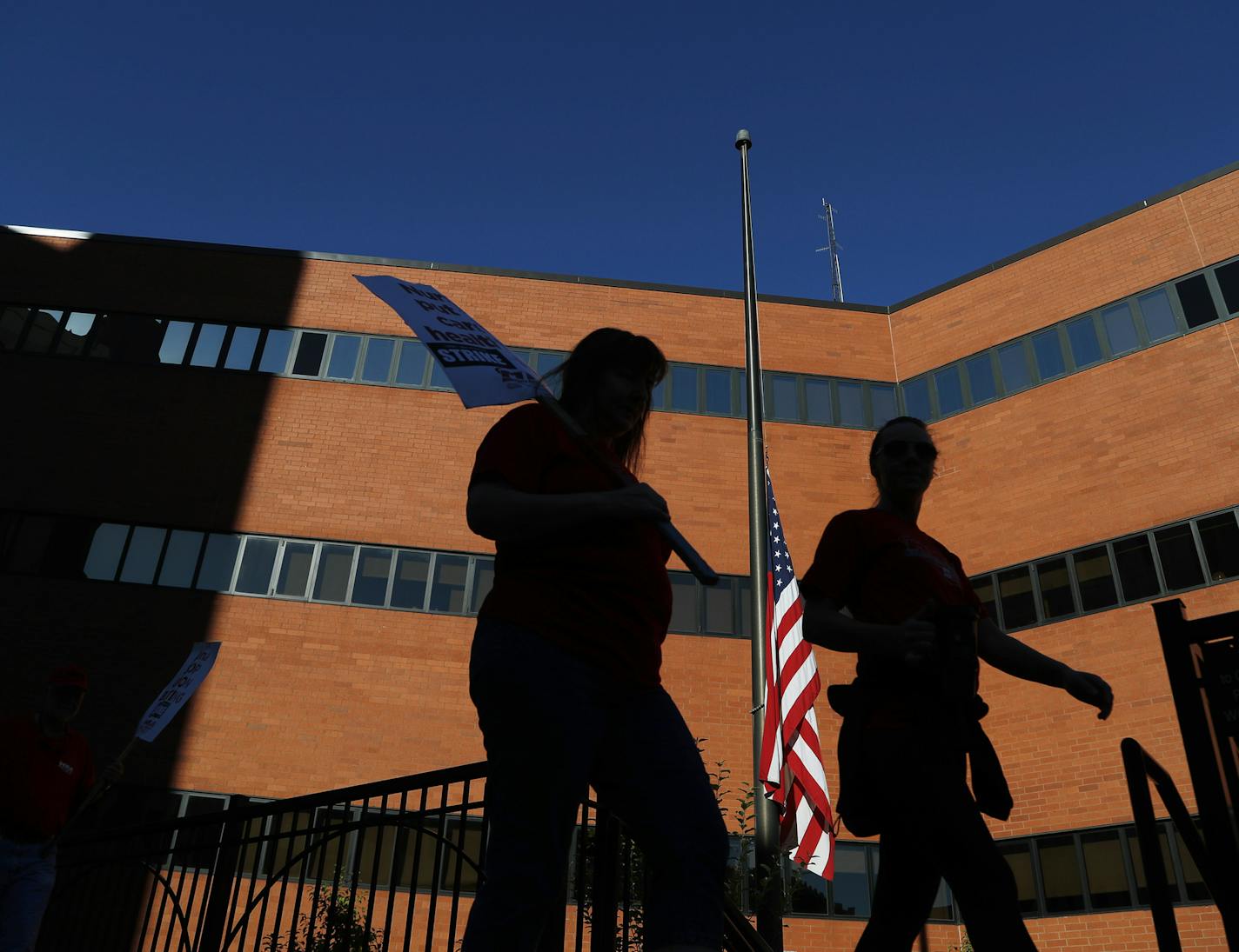 The flag flying at half-staff on Sept. 11 acted as a backdrop for nurses outside United Hospital.