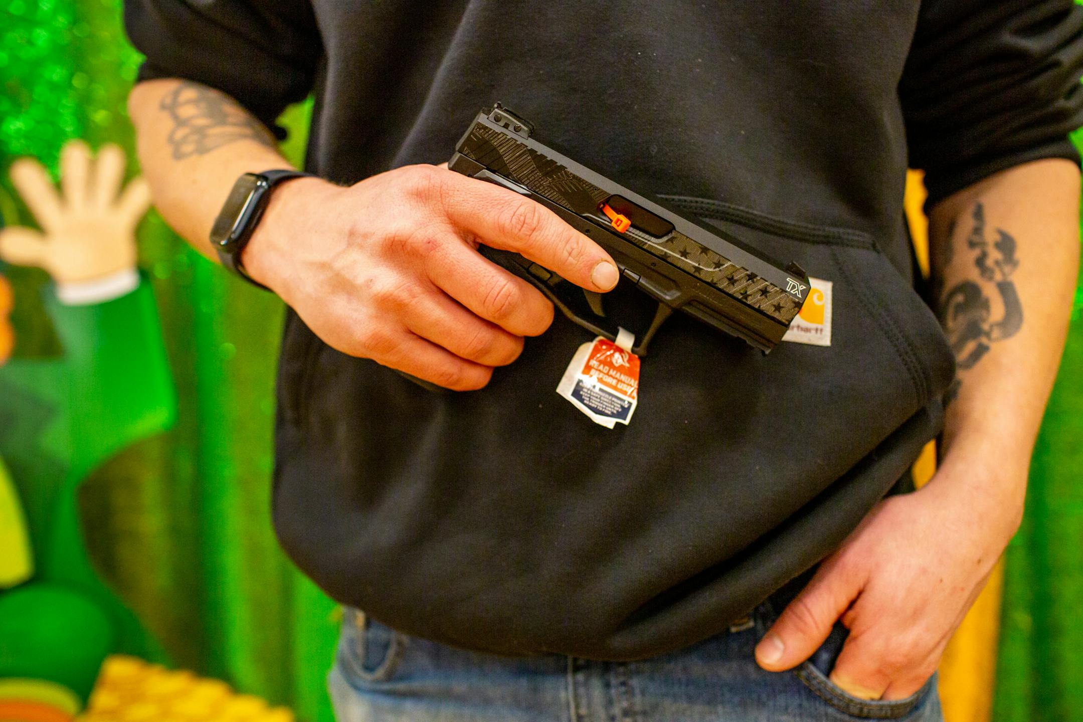 Matt Johnson poses with his new Taurus TX22 pistol during Designer Purse & Gun Bingo.