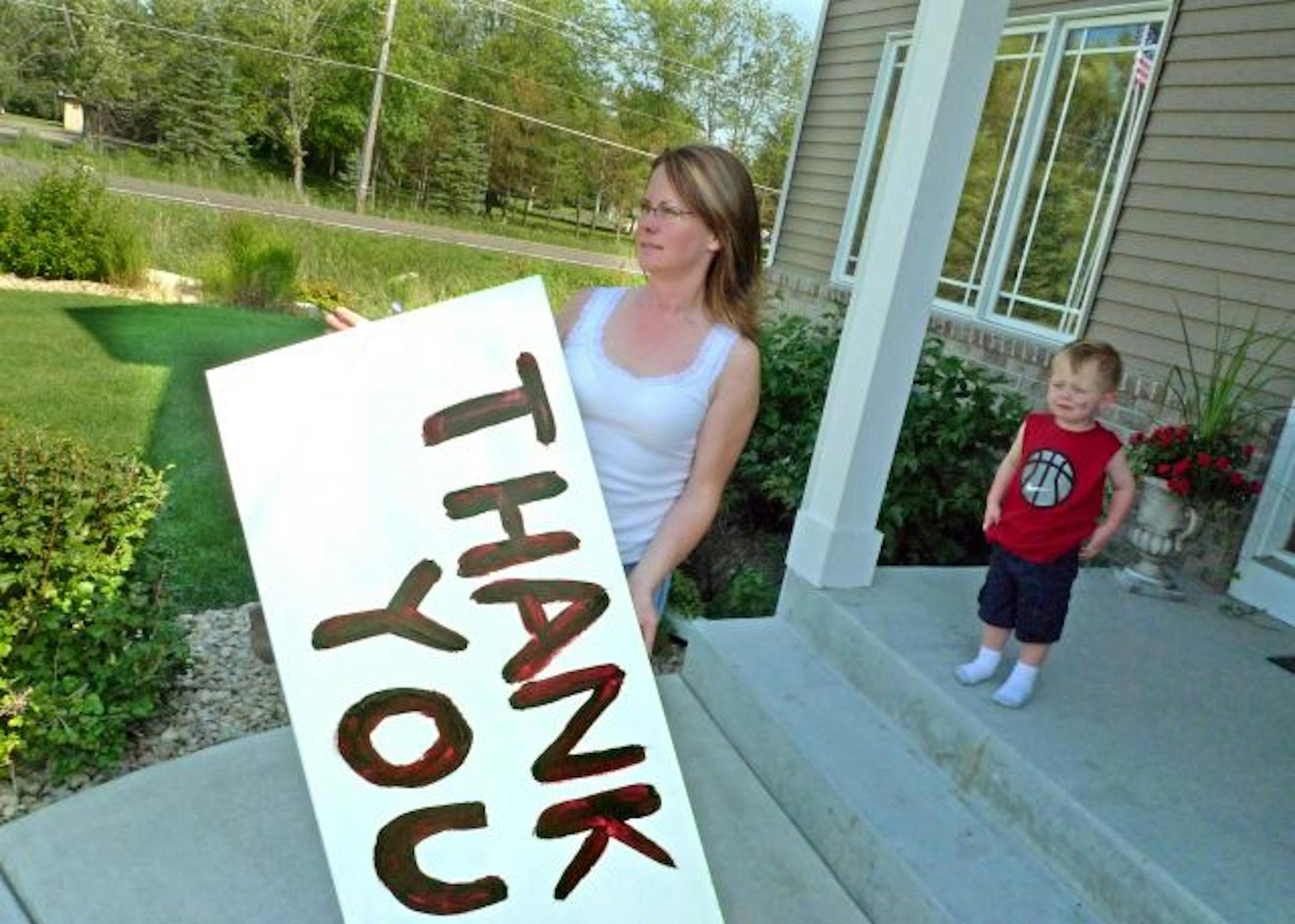 Kary Burggraff holds a 'thank you' sign she made to thank the neighbors for everyone's efforts to prevent a Zumbro House, Inc. group home for teenage boys with mental and developmental disabilities that was planned across the street on Hunter's Trail in Centerville. She said "I don't want people to believe we are against accepting people who are developmentally disabled. I don't think that was the intent of anyone in the neighborhood. the important thing for me is we have about 15 kids just on t