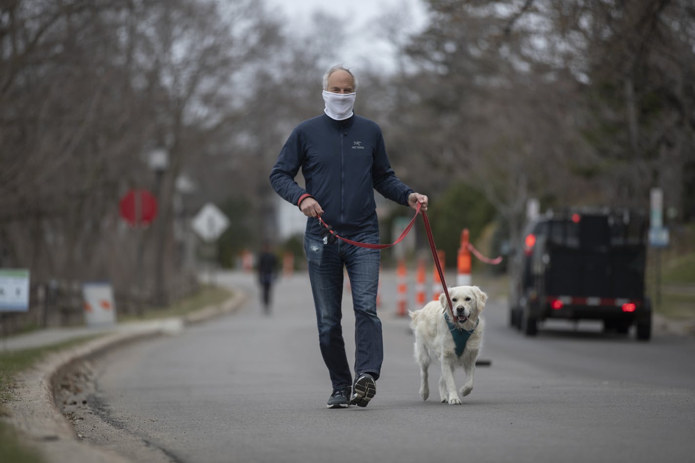 Peter Welles walked his dog Monday on Bde Maka Ska Parkway, where traffic cones are placed to make traffic flow just one way.