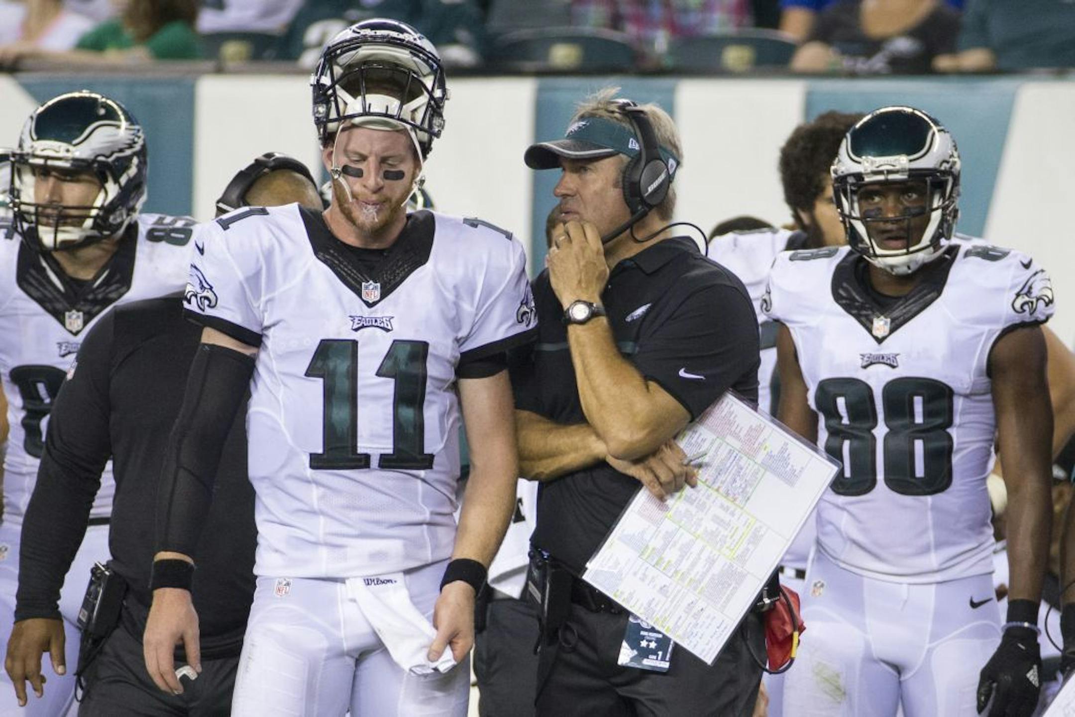 Eagles coach Doug Pederson talked things over with quarterback Carson Wentz (11) during the second half of a preseason game against the Buccaneers on Thursday.