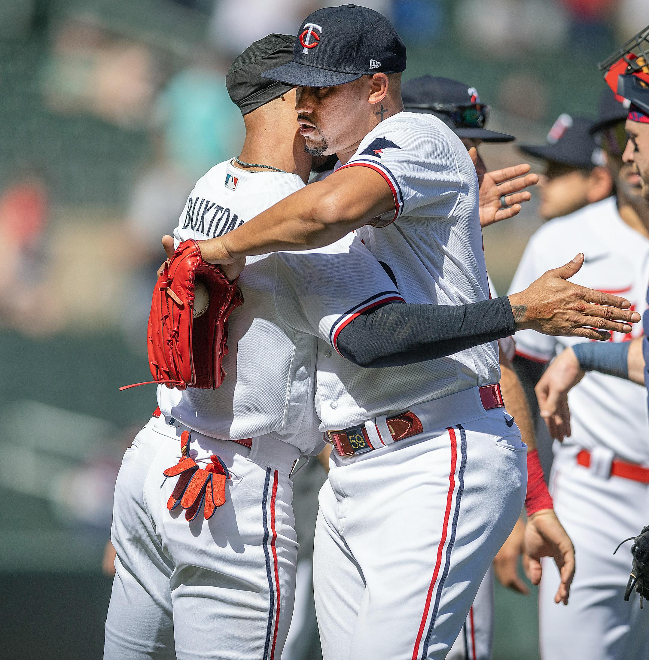 Minnesota Twins relief pitcher Jhoan Duran (59) hugs Minnesota Twins center fielder Byron Buxton (25) after they defeated the Chicago White Sox 3-1.