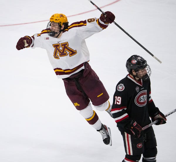 Minnesota Gophers forward Matthew Knies (89) leapt to celebrate teammate Jaxon Nelson's empty net goal late in the third period as his former teammate