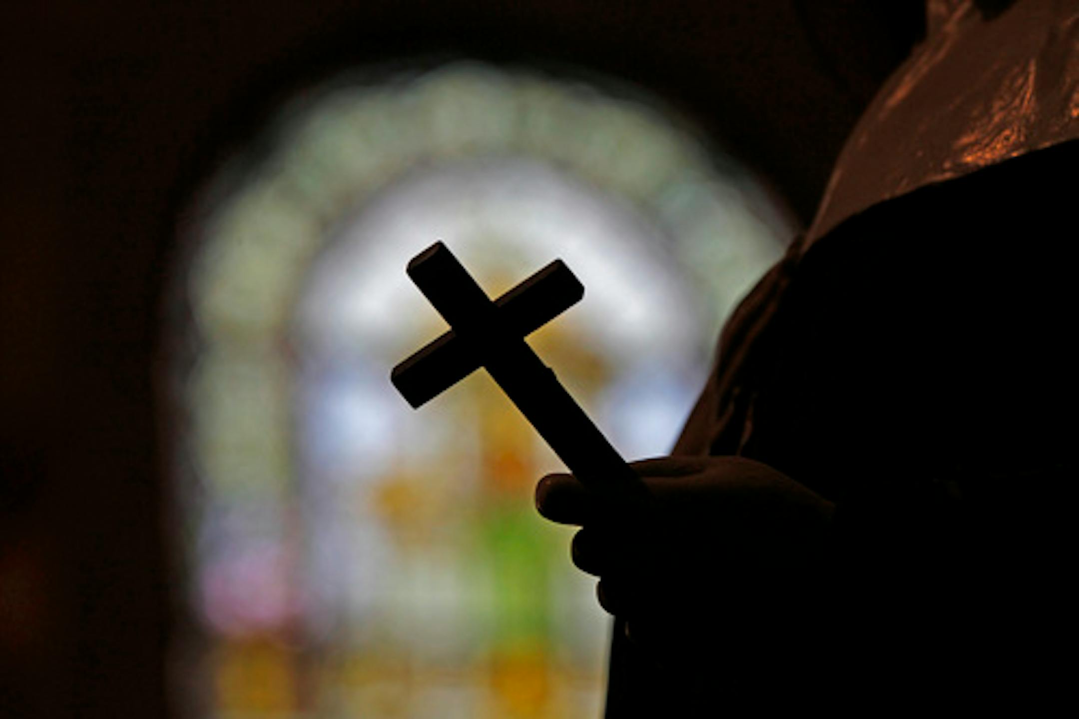 FILE - This Dec. 1, 2012 file photo shows a silhouette of a crucifix and a stained glass window inside a Catholic Church in New Orleans. The FBI has opened a widening investigation into sex abuse in the Roman Catholic Church in New Orleans going back decades, a rare federal foray into such cases looking specifically at whether priests took children across state lines to molest them, officials and others familiar with the inquiry told The Associated Press. (AP Photo/Gerald Herbert, File)