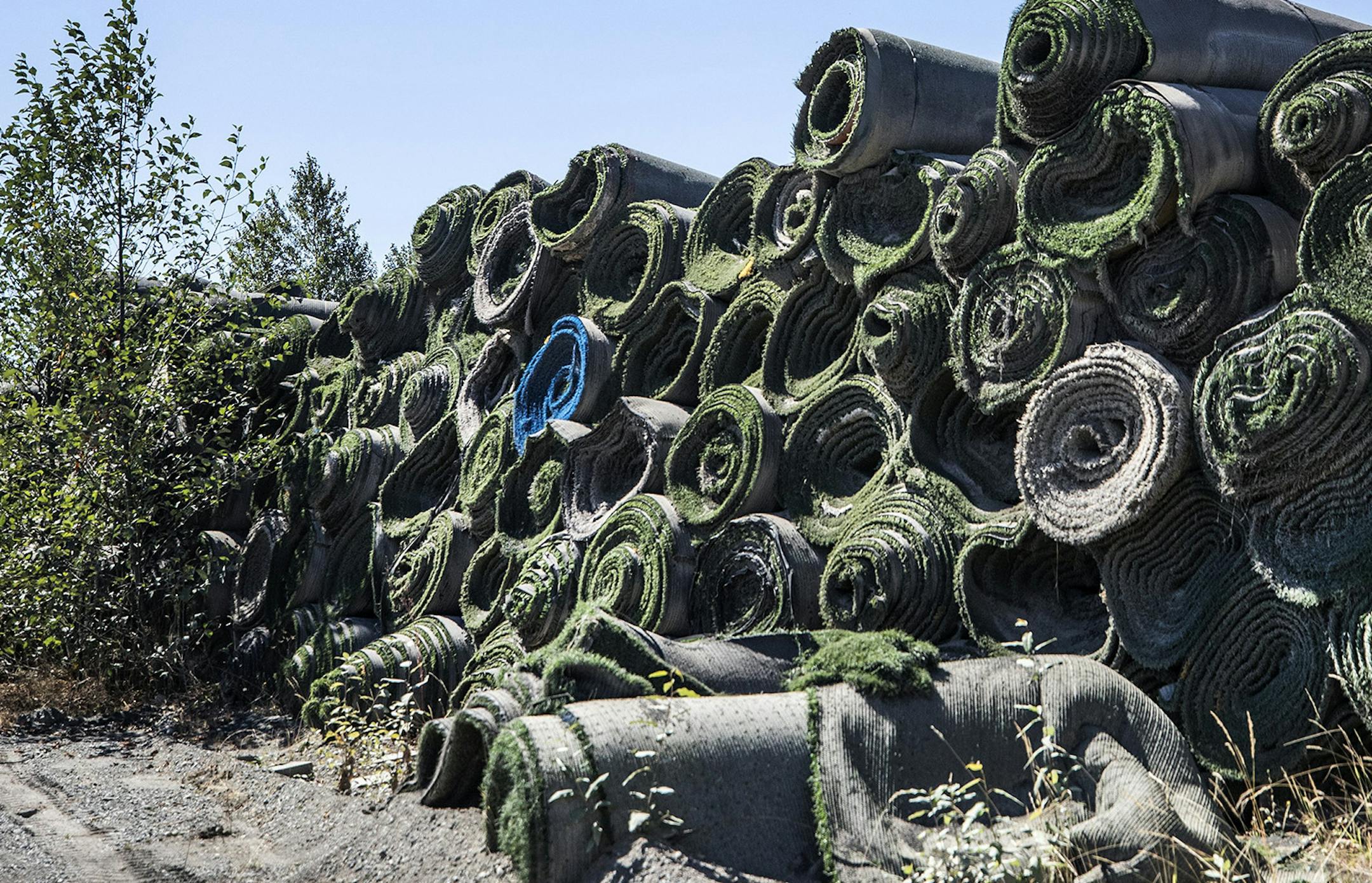 Piles of old Astroturf are stored near the Puyallup River. Astroturf was used for a recent retrofit for the liner of the Electron Hydropower Project. (Steve Ringman/Seattle Times/TNS)