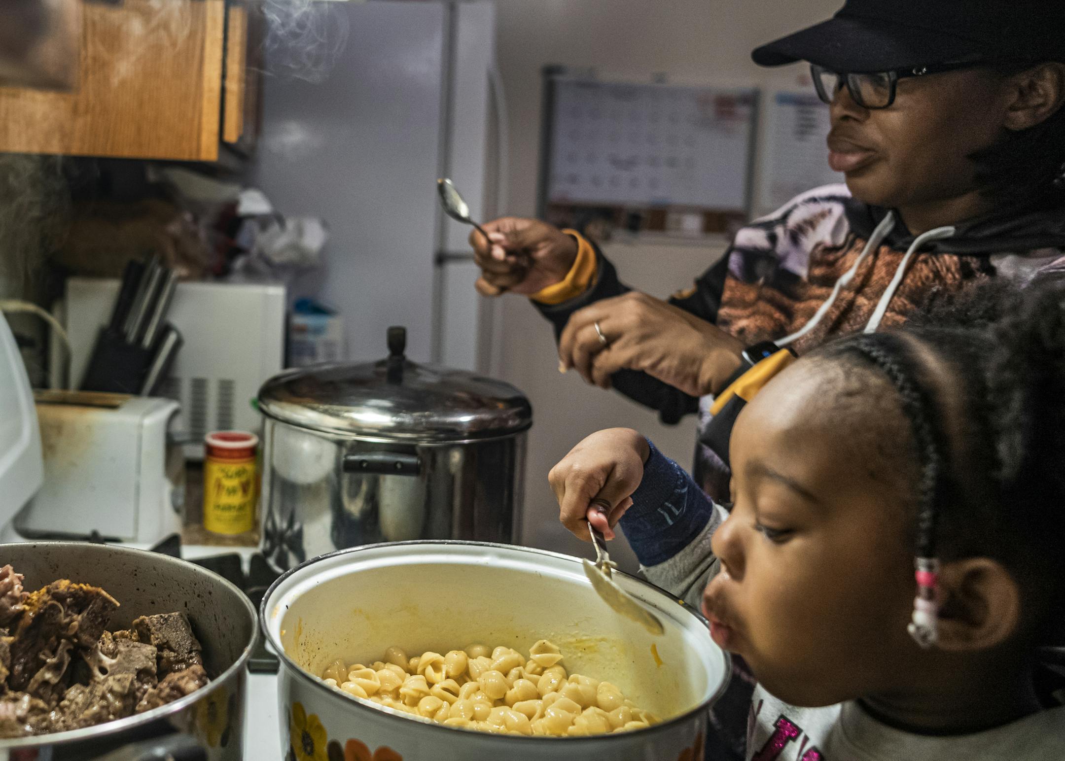 Daughter Frankie Higgins,3, helped her mother Farrah Kennedy make the mac and cheese. The dinner consisted of pork, collard greens, mac and cheese, as well as cornbread. She just returned from a yearlong deployment to the Middle East with the MN National Guard.] . RICHARD TSONG-TAATARII ¥ richard.tsong-taatarii@startribune.com