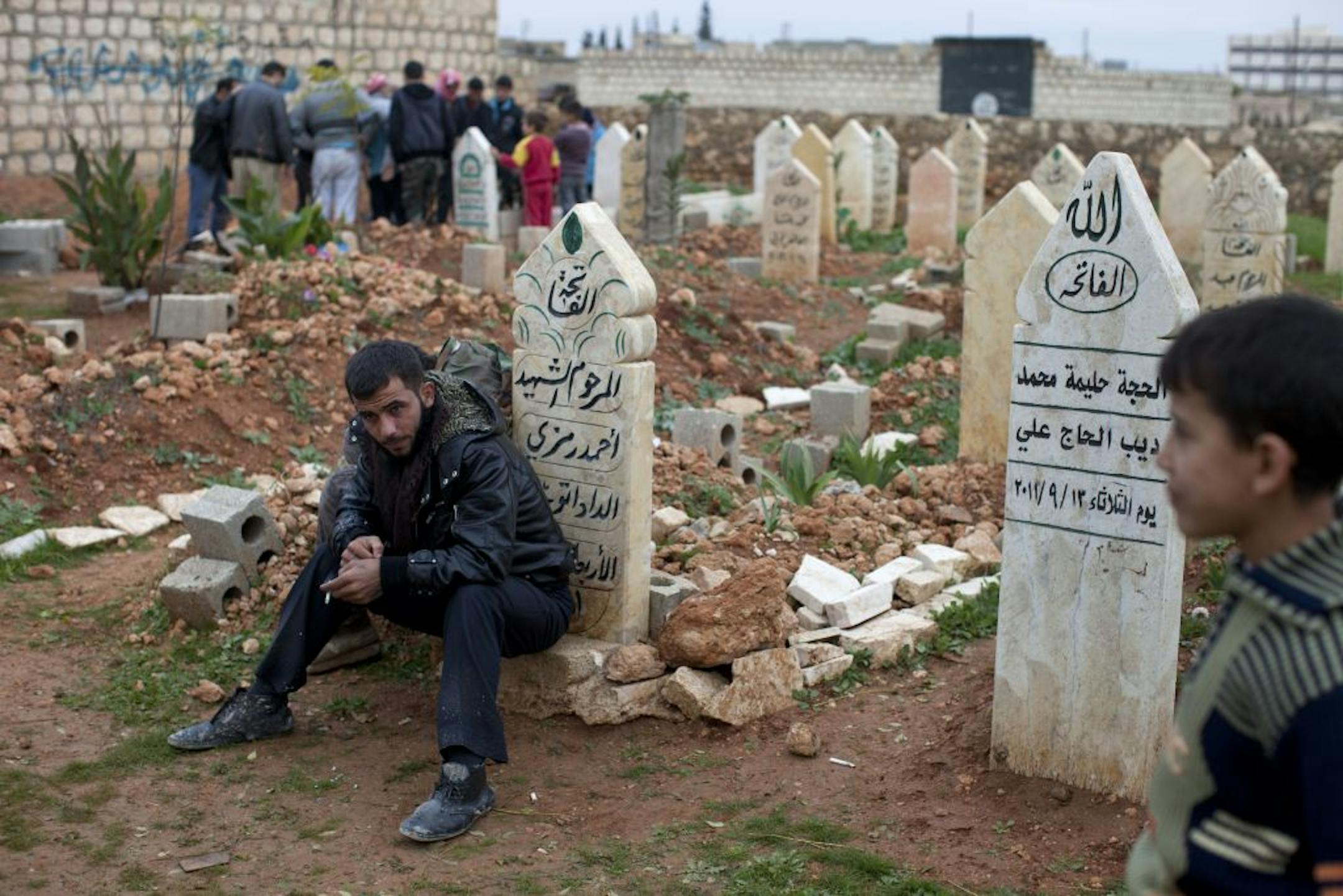 A man sits during a funeral for a Free Syrian Army fighter in Maara, near Aleppo, Syria, Dec. 13, 2012.