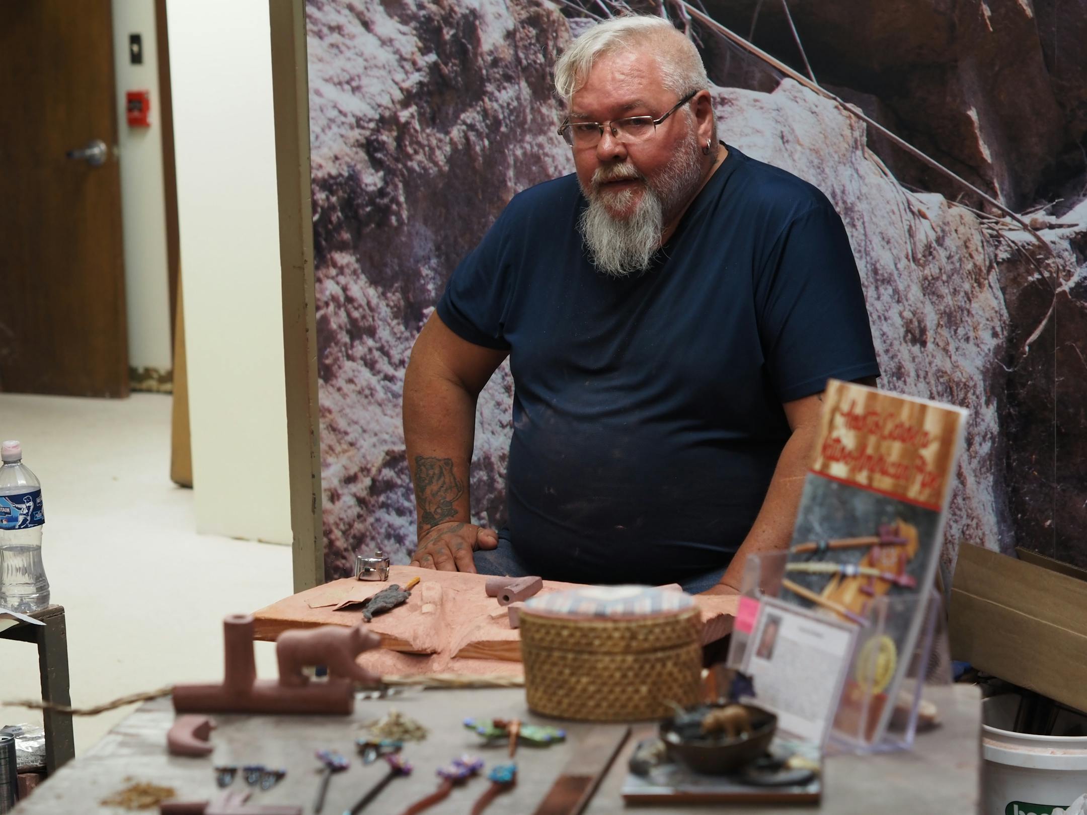 A fourth-generation pipemaker stands near examples of his craft at Pipestone National Monument.