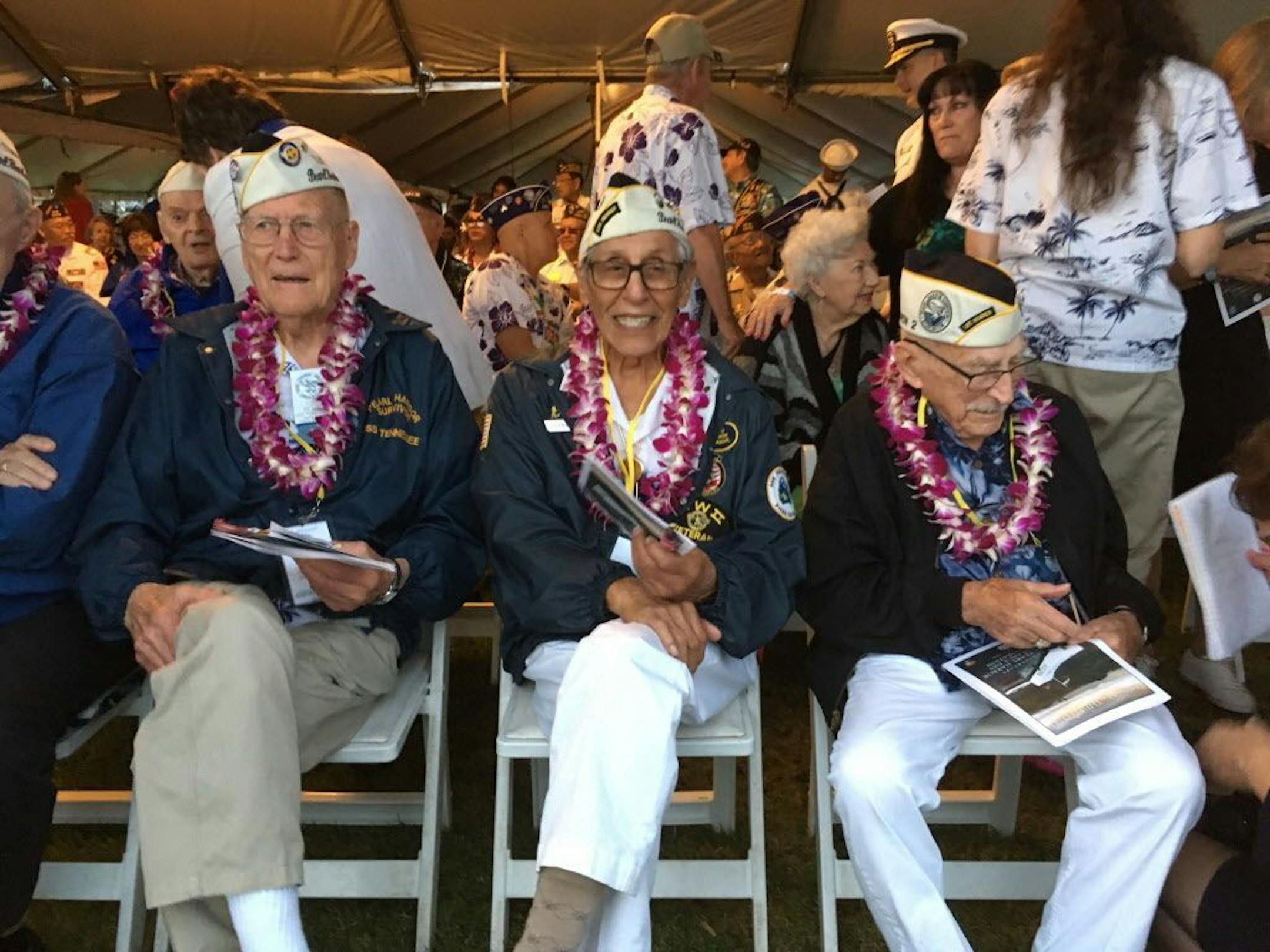 Tom Berg, left, of Port Townsend, Wash., Robert Fernandez, center, of Stockton, Calif., and George Keene of Newhall, Calif., all survivors of the 1941 Japanese attack on Pearl Harbor, take part in the 77th anniversary ceremony Friday, Dec. 7, 2018, at Pearl Harbor, Hawaii. The Navy and National Park Service jointly hosted the remembrance ceremony at a grassy site overlooking the water and the USS Arizona Memorial.