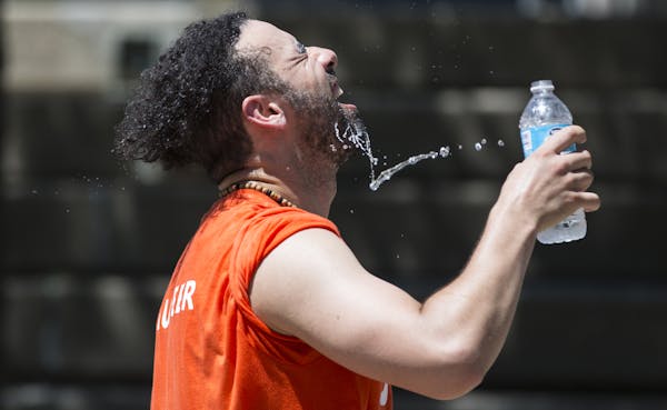 A sweaty Mehdi Kennar poured water on his face during a water break from his world dance workout during the Aquatennial Zumba presented by YWCA in the